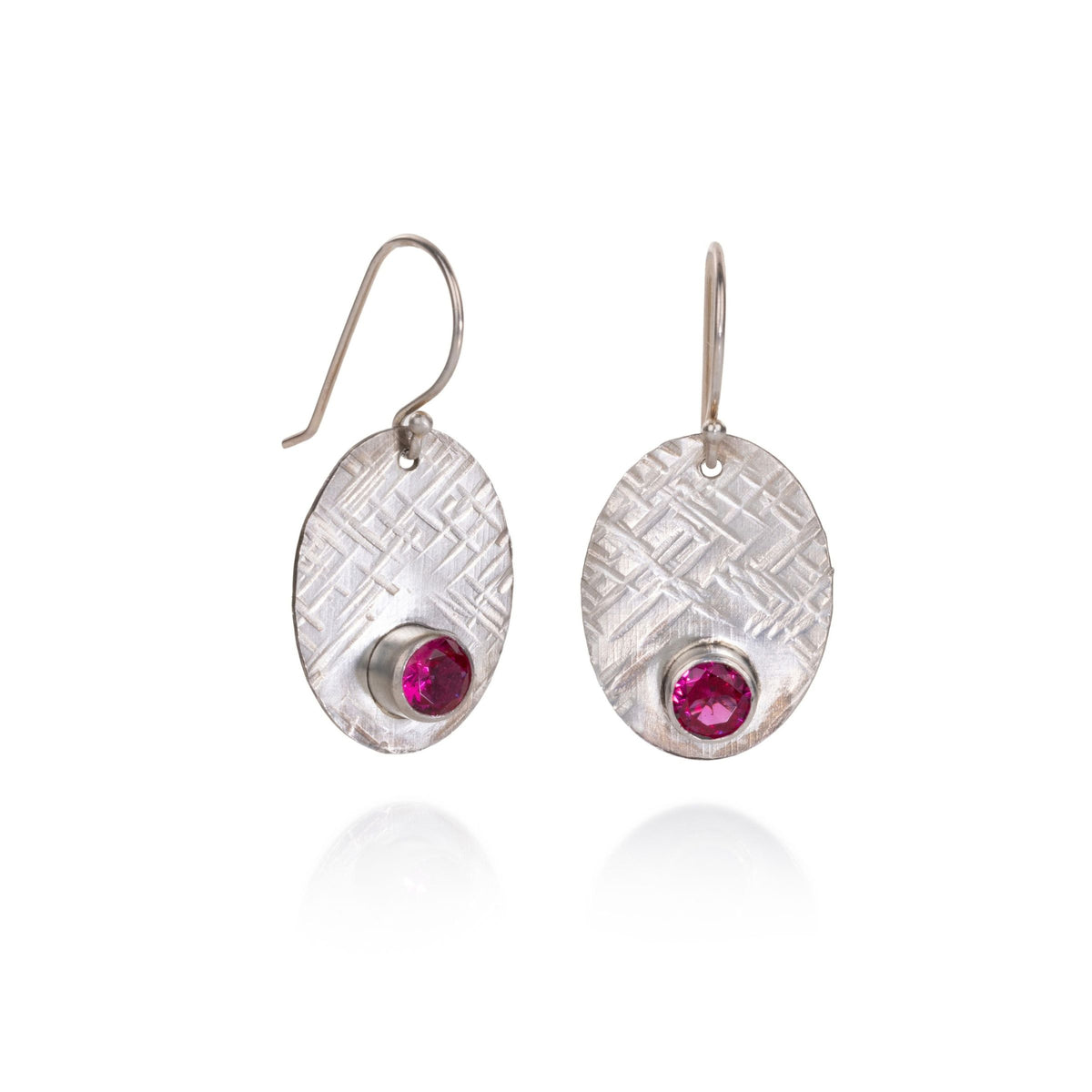 Silver and ruby earrings that have seen tube-set