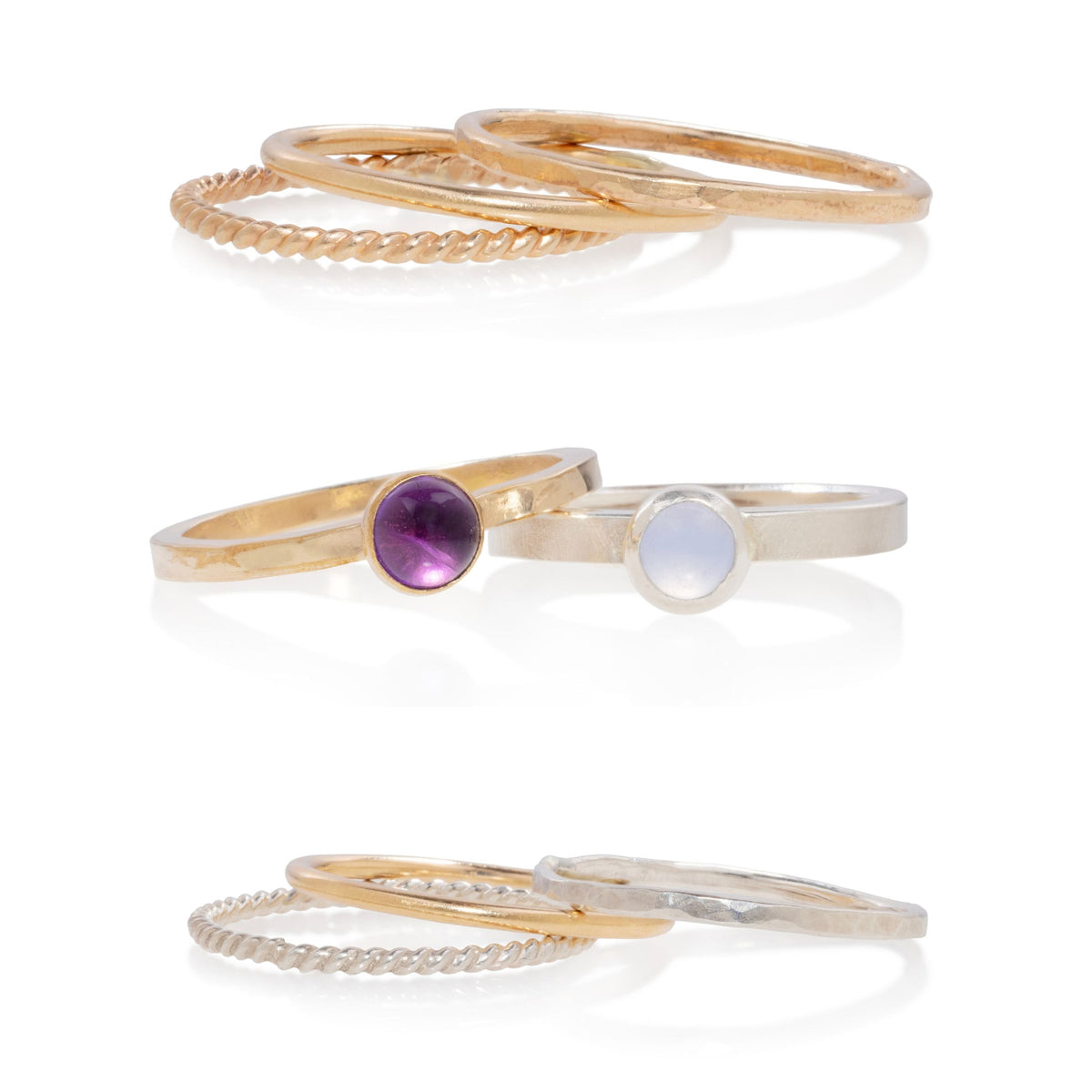 Three sets of minimalist stacking rings on a white background. The top set consists of gold rings, one with a textured rope pattern.